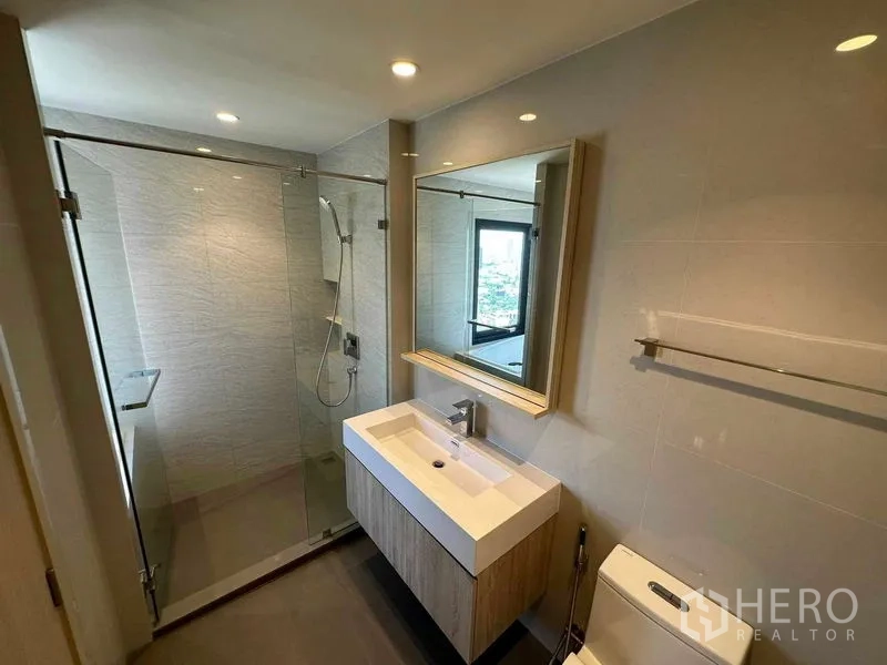 คอนโด ขายในWatthana, Bangkok - ห้องน้ำสไตล์โมเดิร์นพร้อมตู้กระจกอาบน้ำ อ่างล้างหน้าแบบลอย และกระจกบานใหญ่