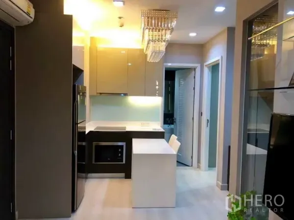 คอนโด ให้เช่าหรือขายในPhaya Thai, Bangkok - ครัวบิวท์อินสมัยใหม่พร้อมไอส์แลนด์ ตู้เงา และโคมระย้า เชื่อมไปยังห้องนอน