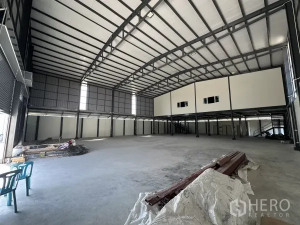 货栈 出租在Prawet, Bangkok - 仓库内部空间开阔，挑高拱形屋顶与钢结构，后方设夹层办公室。