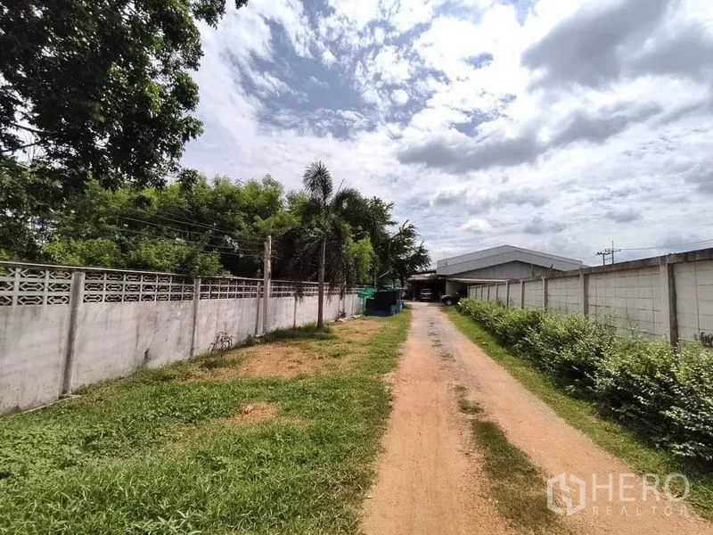 โรงงาน ขายในLat Lum Kaeo, Pathum Thani - ทางเข้าเอกชนมีรั้วคอนกรีตและต้นไม้ นำสู่คลังสินค้าในเขตลาดหลุมแก้ว