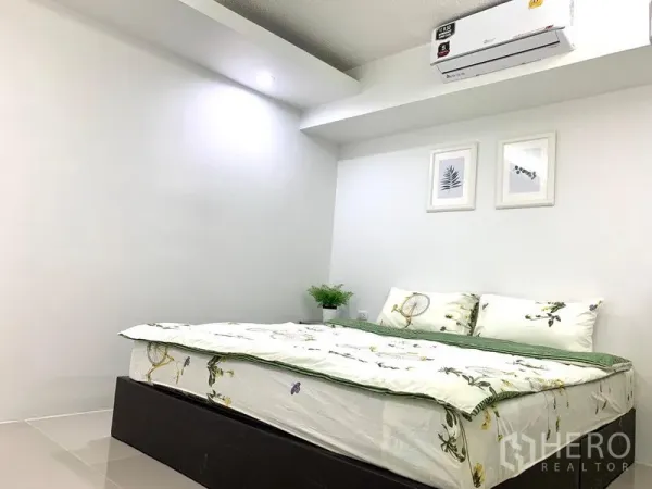 คอนโด ให้เช่าหรือขายในKhlong Toei, Bangkok - มุมห้องนอนพร้อมไฟฝังฝ้า ภาพแขวนลายพรรณไม้ และเตียงคู่ปูผ้าเรียบร้อย