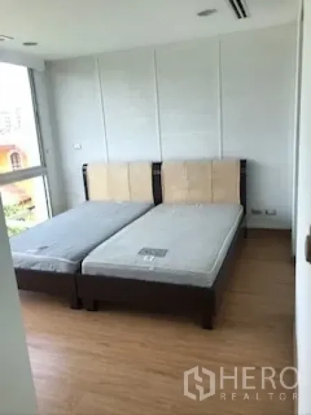 ทาวน์เฮาส์ ให้เช่าหรือขายในYan Nawa, Bangkok - ห้องนอนที่สอง เตียงเดี่ยวคู่ ผนังสีขาวและมุมกระจก