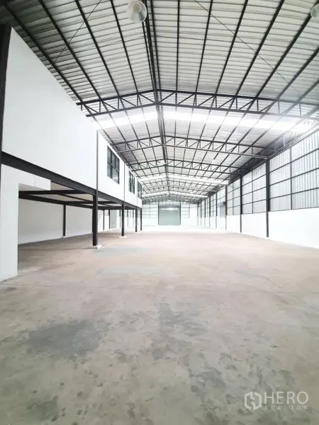 货栈 出租在Bang Khen, Bangkok - 仓库内部空间宽敞，钢桁架高顶，混凝土地面，带窗户的夹层办公区。
