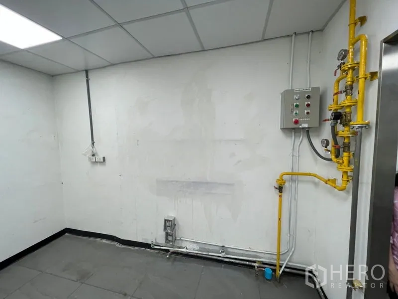 零售空间 出租在Watthana, Bangkok - 室内公用设施墙，带黄色燃气管道、控制面板与管线。
