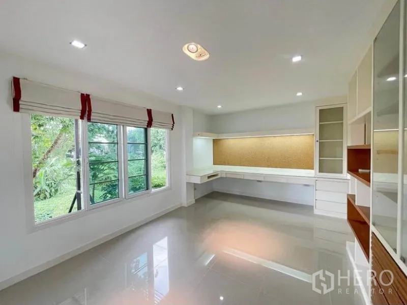 Townhouse for rent in Phasi Charoen, Bangkok - Light-filled study room with built-in desks and shelving facing greenery.