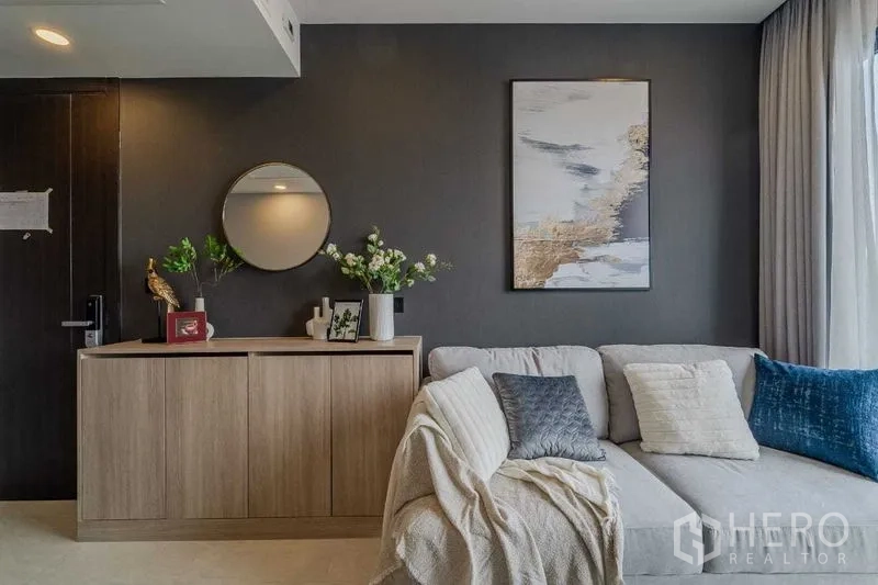 คอนโด ให้เช่าในPathum Wan, Bangkok - พื้นที่นั่งเล่นร่วมสมัย โซฟาตัวแอล ตู้คอนโซล และภาพตกแต่งผนัง