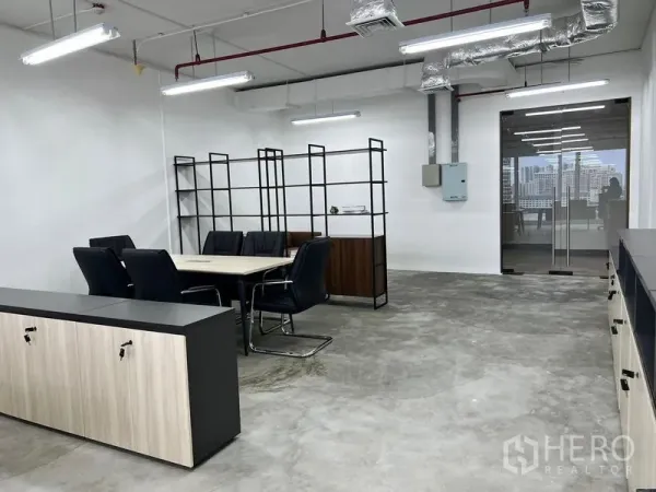 办公空间 出租在Sathon, Bangkok - 会议区配黑色行政椅、开放式隔架与玻璃门入口。