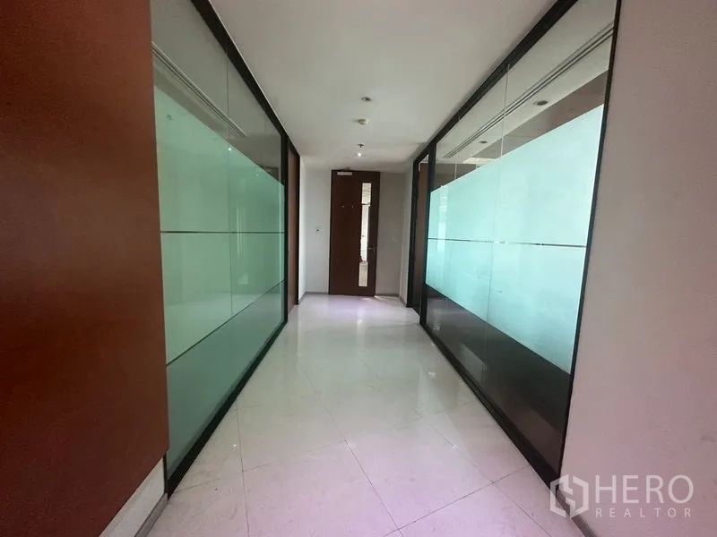 Office Space for rent in Khlong Toei, Bangkok - Bright hallway with tiled floor and glass walls leading to offices.