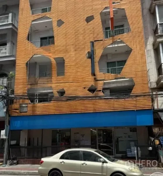 พื้นที่ขายปลีก ให้เช่าในWatthana, Bangkok - อาคารพาณิชย์สี่ชั้นกรุงานไม้สีส้ม พร้อมแถบสีน้ำเงิน ชั้นล่างเป็นหน้าร้านและมีที่จอดริมถนน