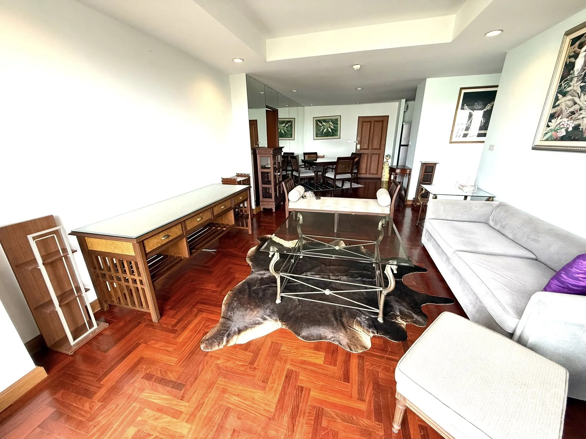 Condominium for rent in Sathon, Bangkok - Living room showcasing long console table, glass coffee table and cowhide rug.
