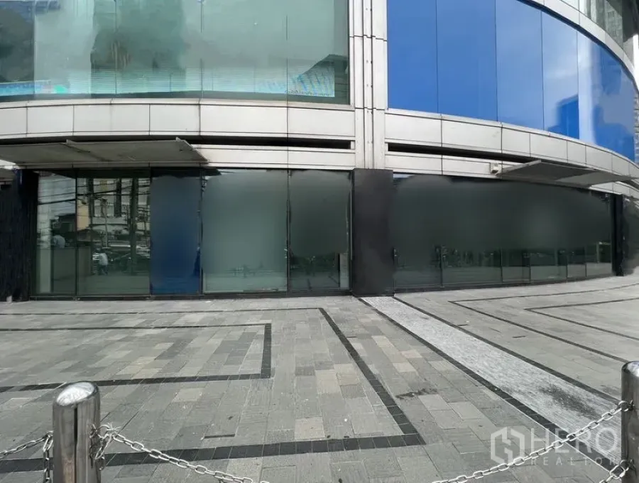 零售空间 出租 - 街层大面积店面玻璃与石材广场，配不锈钢柱与链条围栏