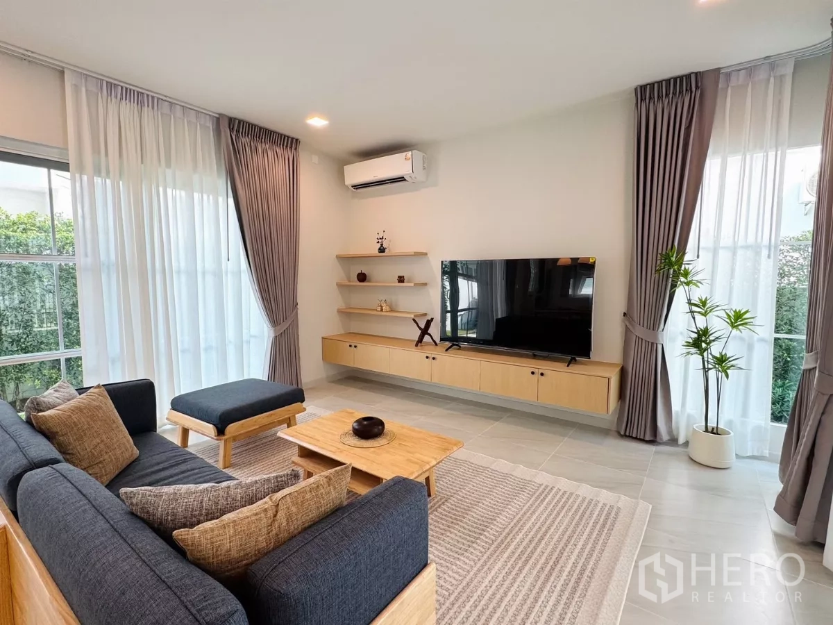 Detached House for rent in Bang Phli, Samut Prakan - Cozy living area with sofa, floating TV console and corner windows.