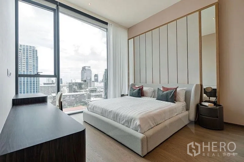 Condominium for rent - Master bedroom with upholstered bed and skyline views through large windows.