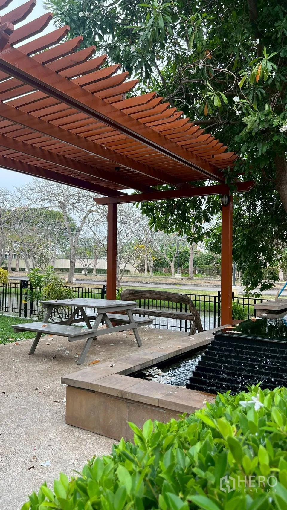 Detached House for rent in Lat Krabang, Bangkok - Shaded wooden pergola with picnic table beside a water feature and canal view.