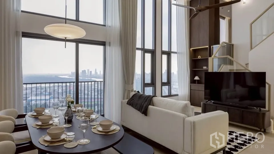 Condominium for rent in Khlong Toei, Bangkok - Open-plan living and dining with floor-to-ceiling windows showcasing city and river views.