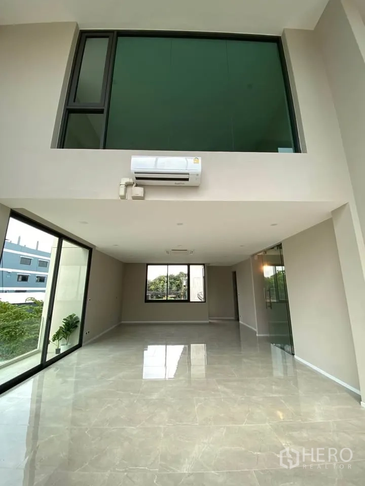Home Office for rent or sale in Suan Luang, Bangkok - Grand window wall facing a residential view with trees.
