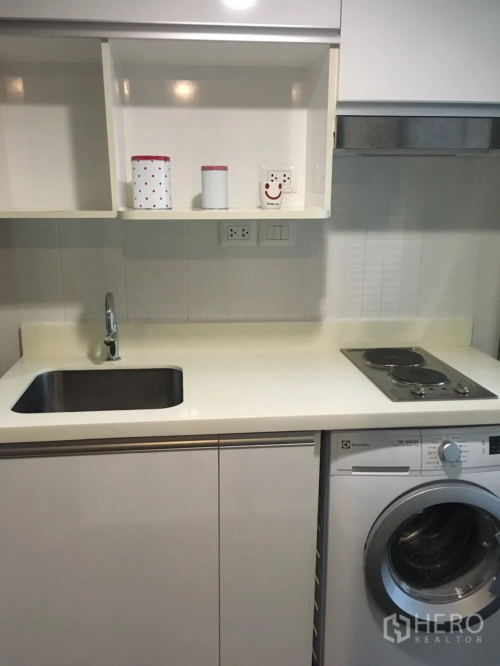 คอนโด ให้เช่าในKhlong Toei, Bangkok - ครัวสีขาวกะทัดรัดพร้อมซิงก์ เตาไฟฟ้า และเครื่องซักผ้าใต้เคาน์เตอร์