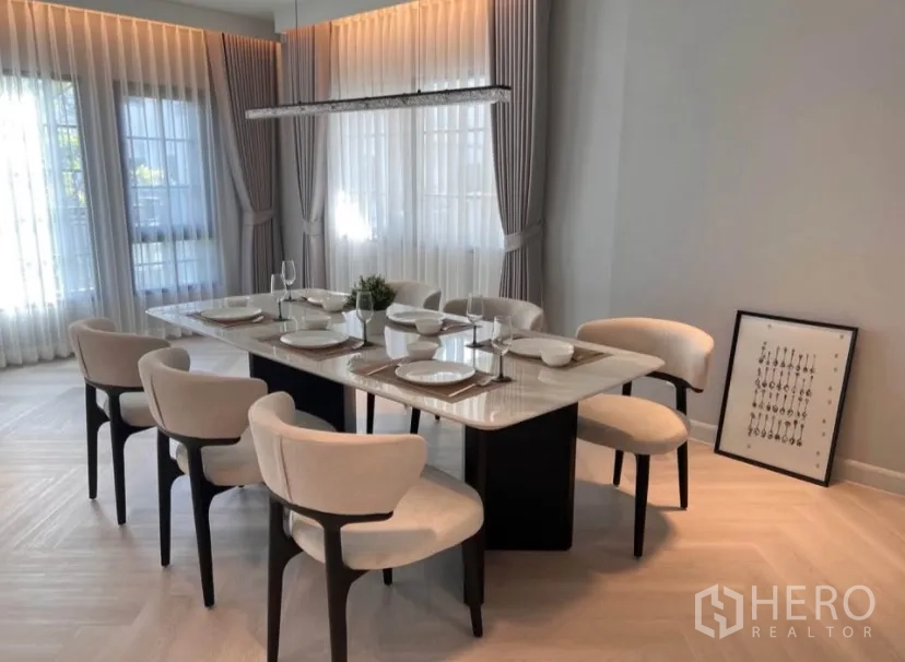 Detached House for rent in Bang Phli, Samut Prakan - Dining area with a marble-top table set for six and a contemporary linear chandelier.