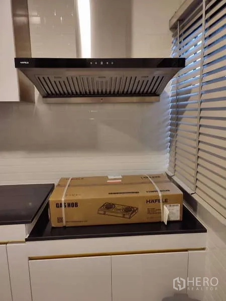 Detached House for rent in Bang Phli, Samut Prakan - Modern range hood above countertop with window blinds in a fitted kitchen.