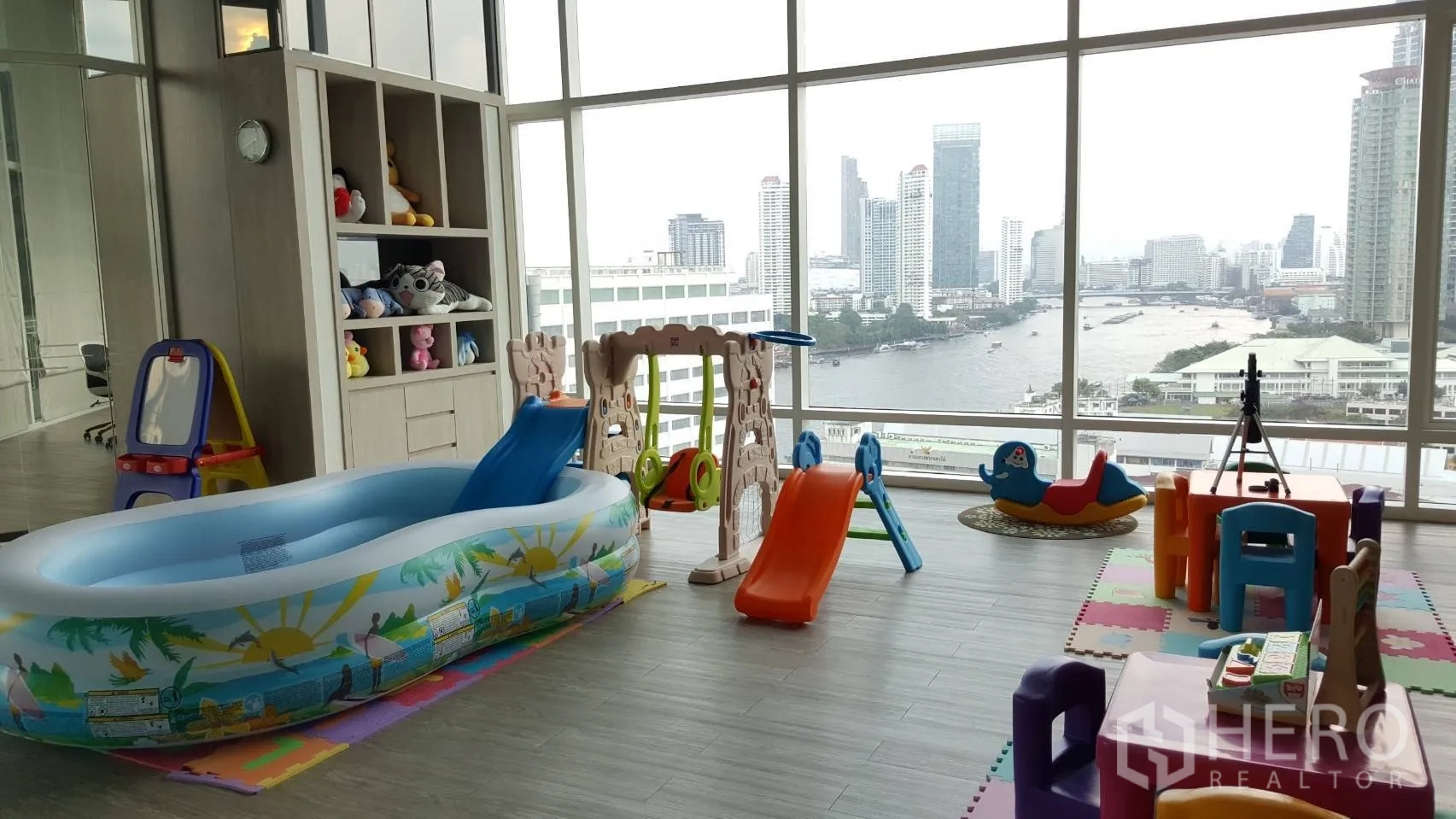 Condominium for rent in Bang Kho Laem, Bangkok - Indoor kids’ playroom with slides and toys, floor-to-ceiling windows and river views in the condominium.