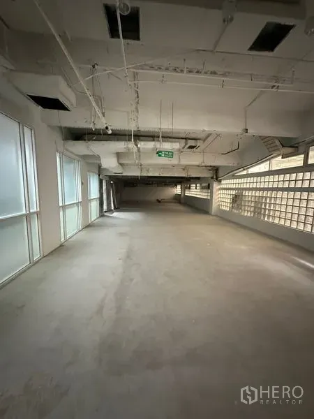 零售空间 出租 - 125平米未装修零售铺，工业风天花，紧急出口标识，玻璃砖与窗户引入自然光。