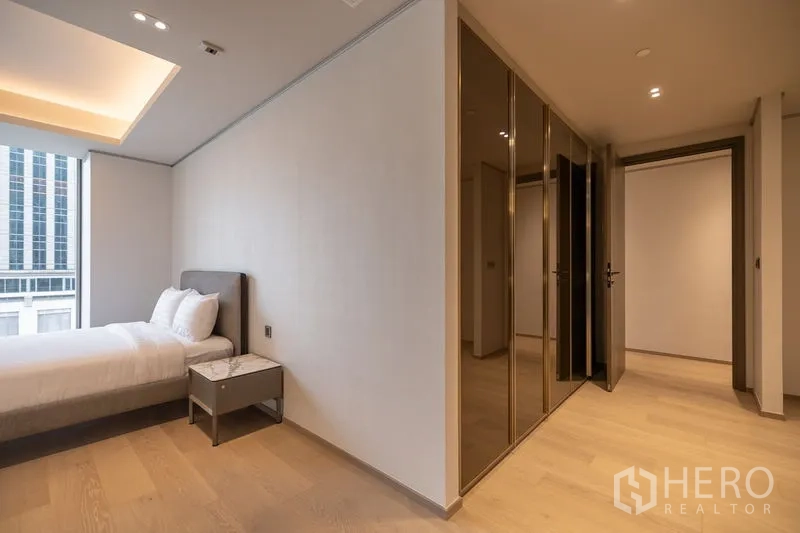 คอนโด ให้เช่าในPathum Wan, Bangkok - ห้องนอนมีหน้าต่างบานใหญ่ เตียง และตู้เสื้อผ้ามันวาว เห็นอาคารเมืองด้านนอก