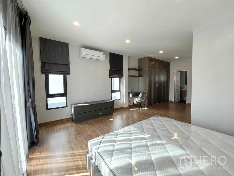 Detached House for rent in Don Mueang, Bangkok - Spacious master bedroom with wood floors, air conditioning, built-in wardrobes and ensuite access.