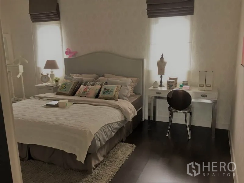 Detached House for rent or sale in Bang Kapi, Bangkok - Cozy bedroom with double bed, bedside lamps and a study vanity.