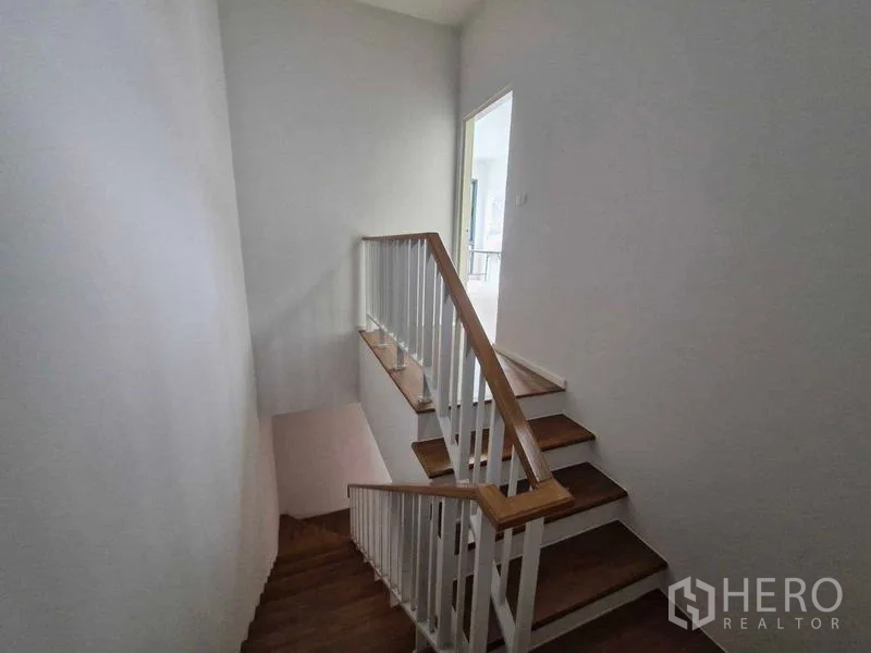 联排别墅 出售在Phra Pradaeng, Samut Prakan - 楼梯平台，连接楼上房间，自然采光良好