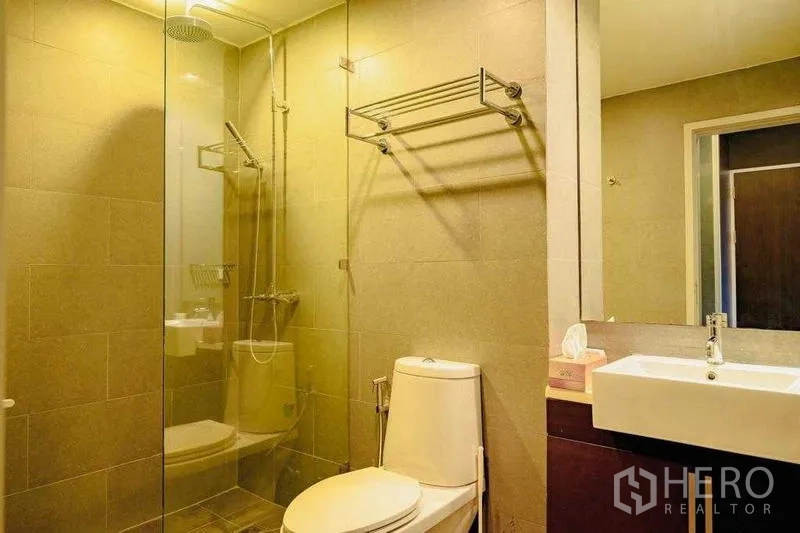 Condominium for rent in Watthana, Bangkok - Modern bathroom with glass shower enclosure, rain shower and vanity.
