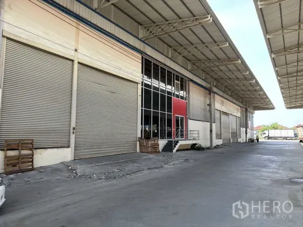 工厂 出租在Bang Phli, Samut Prakan - 邦普里工厂外部的遮雨装卸区，多个卷帘门与宽阔混凝土车道相连。