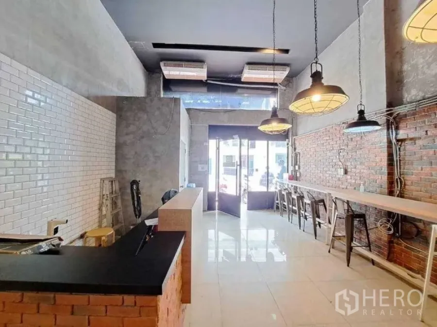 零售空间 出租在Khlong Toei, Bangkok - 工业风零售室内，砖墙、吊灯与宽阔玻璃门面