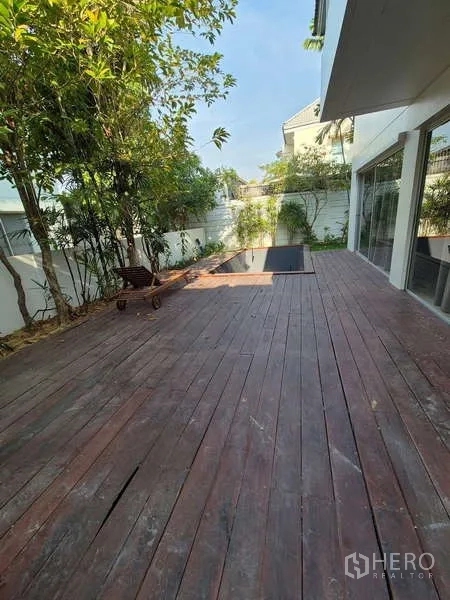 独立式住宅 出租在Bang Kruai, Nonthaburi - 沿屋侧的大型木平台，绿植与小泳池。