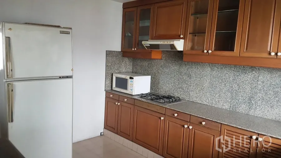 คอนโด ให้เช่าในKhlong Toei, Bangkok - ครัวปิด ตู้ไม้ เคาน์เตอร์หินแกรนิต เตาแก๊ส ไมโครเวฟ และตู้เย็นสีขาว