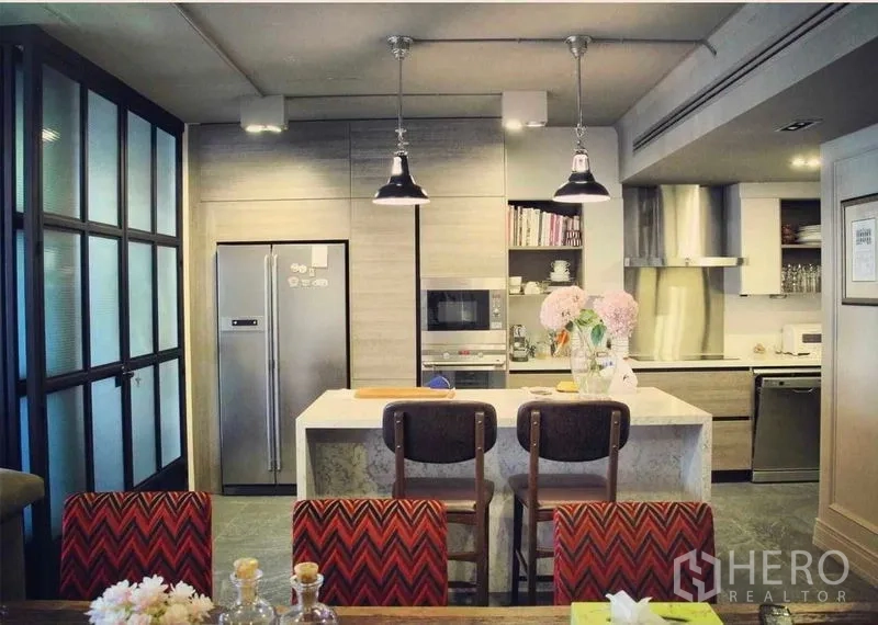 Condominium for sale in Pathum Wan, Bangkok - Modern kitchen with stone island, pendant lights, built-in fridge and oven.