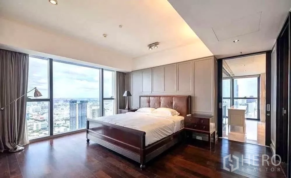 Condominium for rent in Sathon, Bangkok - Master bedroom with upholstered headboard, wood floors and dramatic city skyline view.