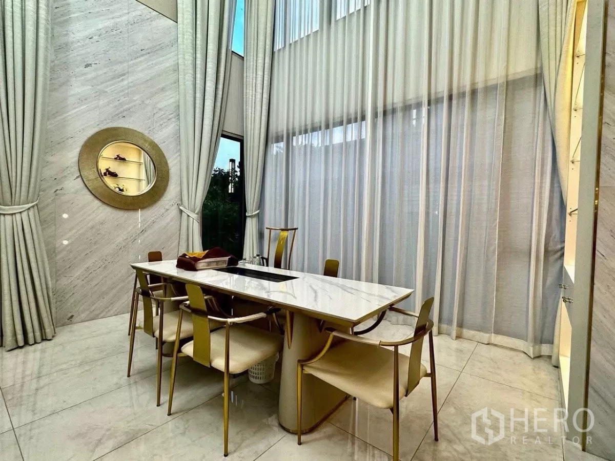 Detached House for sale in Saphan Sung, Bangkok - Formal dining area with marble table, tall drapes and large windows for natural light.