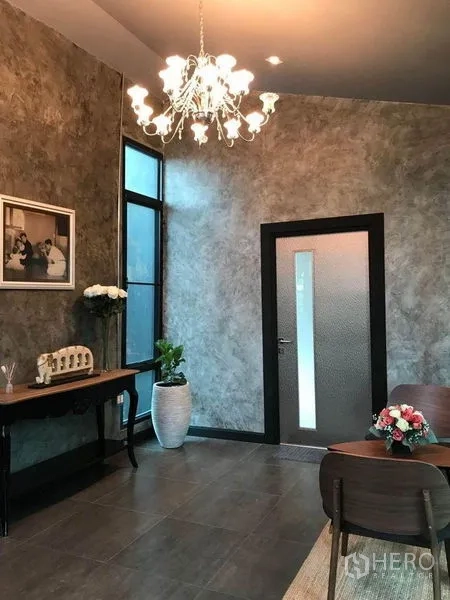 Office Space for rent in Bang Kapi, Bangkok - Reception area with chandelier, textured walls and a dark framed door.