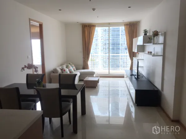 公寓 出租在Sathon, Bangkok - 明亮的客餐厅，配沙发与电视柜，落地窗通向阳台，可观曼谷天际线。