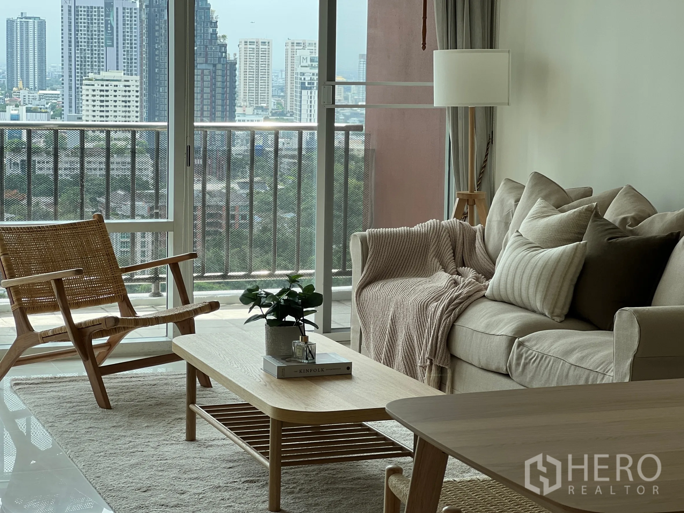 คอนโด ให้เช่าในWatthana, Bangkok - โซฟาอบอุ่นกับโต๊ะกลางไม้ข้างหน้าต่างเต็มบานและระเบียงชมวิวเมือง