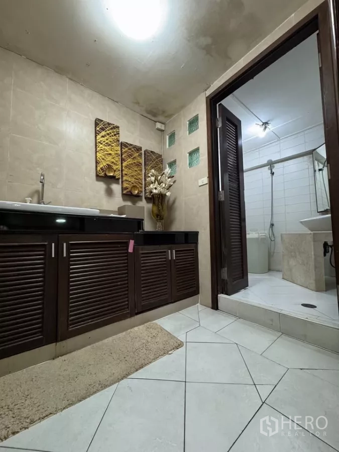 店屋 出租在Bang Rak, Bangkok - 浴室配深色木质洗手台，旁为白砖淋浴间。