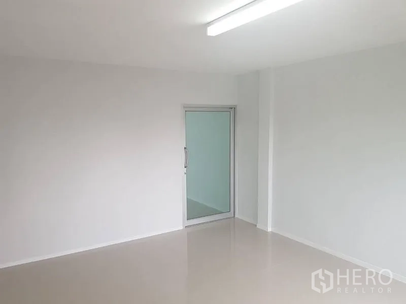 店屋 出租或出售在Lat Phrao, Bangkok - 明亮简洁房间，平整地面与通向内侧的玻璃门。