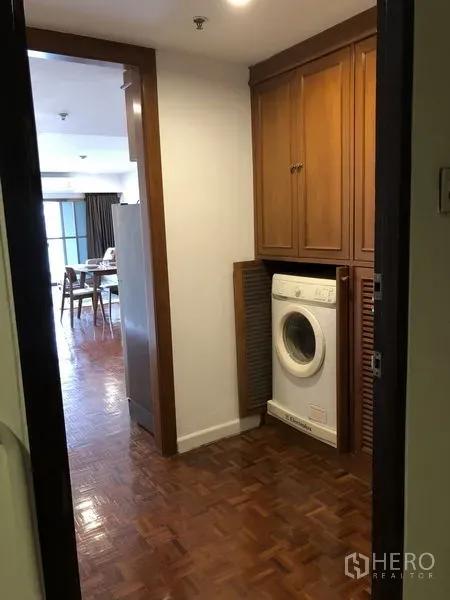 Condominium for rent or sale in Sathon, Bangkok - Utility corridor with built-in wooden cabinets and a front-loading washing machine.