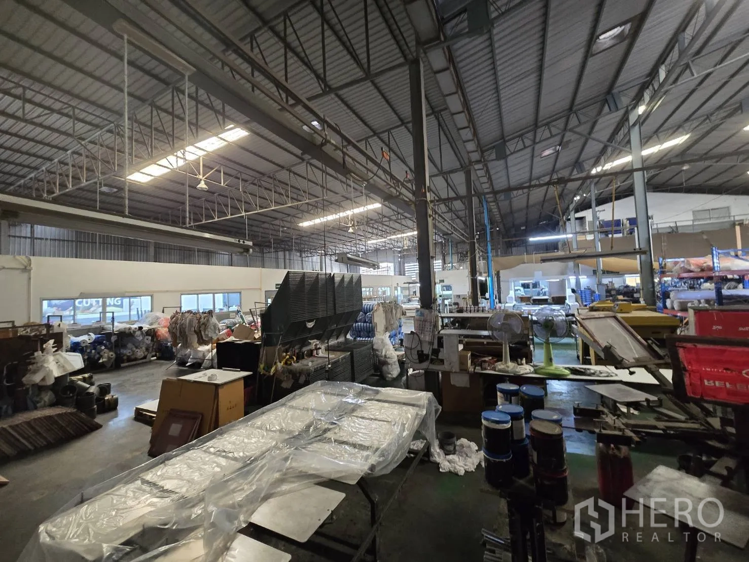 Factory for rent in Sam Phran, Nakhon Pathom - Open production floor with metal trusses, fluorescent lighting, and equipment stations.