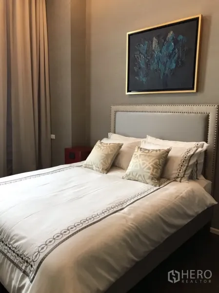 Condominium for rent or sale in Huai Khwang, Bangkok - Second bedroom with padded headboard, accent pillows and abstract artwork above the bed.