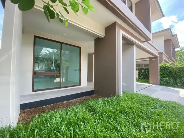 บ้าน ให้เช่าในBang Kapi, Bangkok - เฉลียงหน้าบ้านมีประตูกระจกบานเลื่อน เชื่อมสู่สนามหญ้าขนาดกะทัดรัด