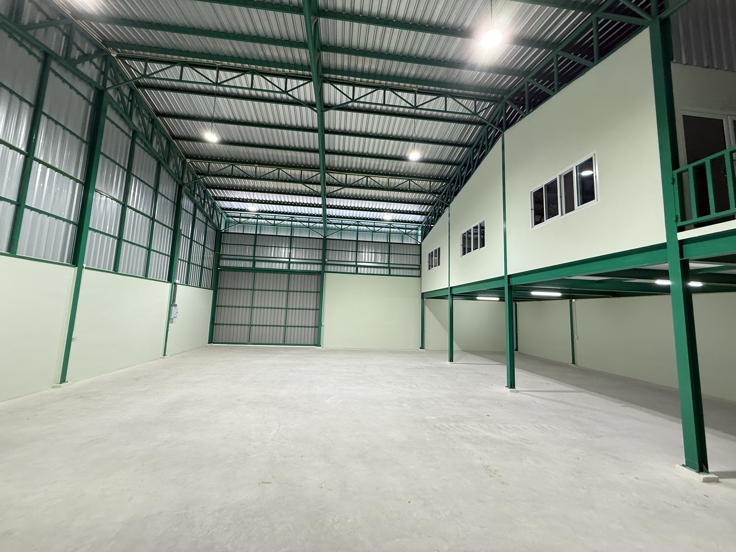Warehouse for rent in Lat Krabang, Bangkok - Open storage bay facing mezzanine offices with steel supports beneath.