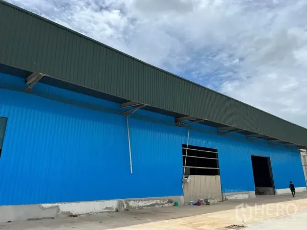 Warehouse for rent in Lat Krabang, Bangkok - Front facade of the warehouse showing multiple roller shutter openings and truck-access driveway.
