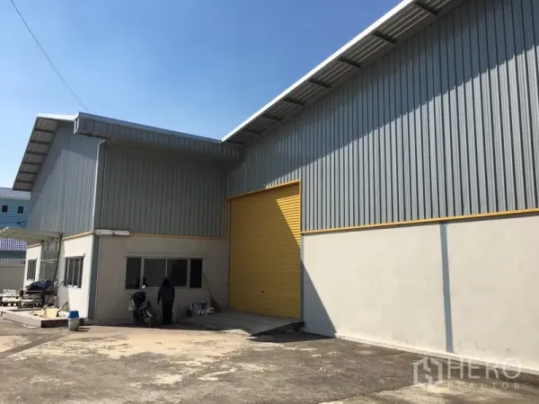 คลังสินค้า ให้เช่าในSaphan Sung, Bangkok - ด้านหน้าโกดังพร้อมประตูม้วนสูงสีเหลืองและทางโหลดสินค้า