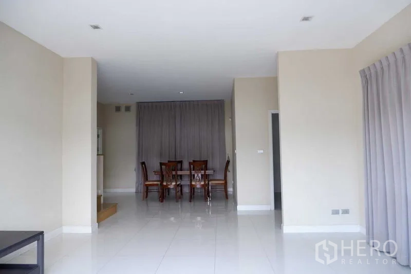 บ้าน ขายในLat Krabang, Bangkok - โถงรับแขกเชื่อมส่วนทานอาหาร พื้นกระเบื้องเงาและผ้าม่านบานใหญ่